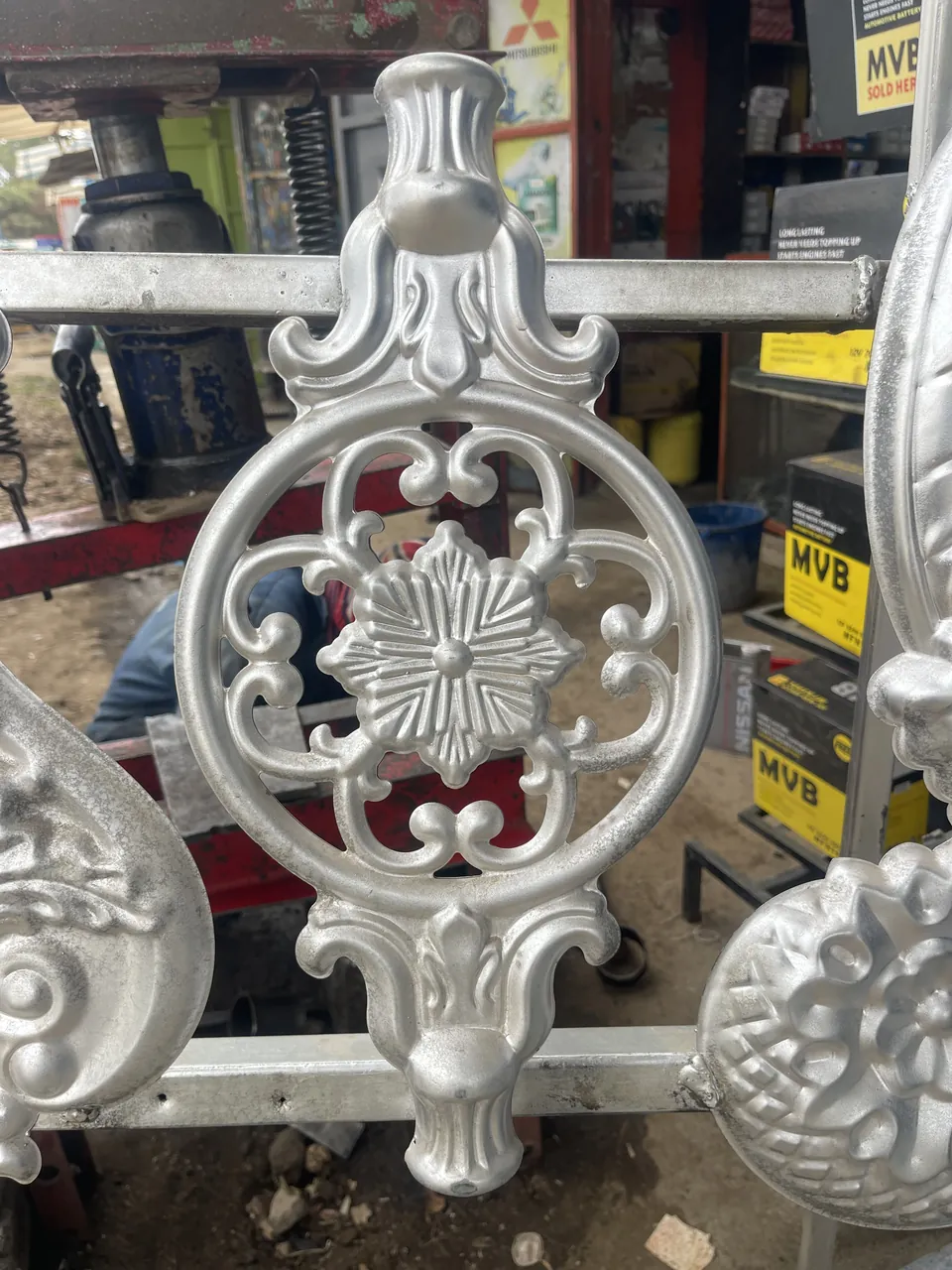 Silver-colour round gate flower with open scrollwork and a central floral motif
